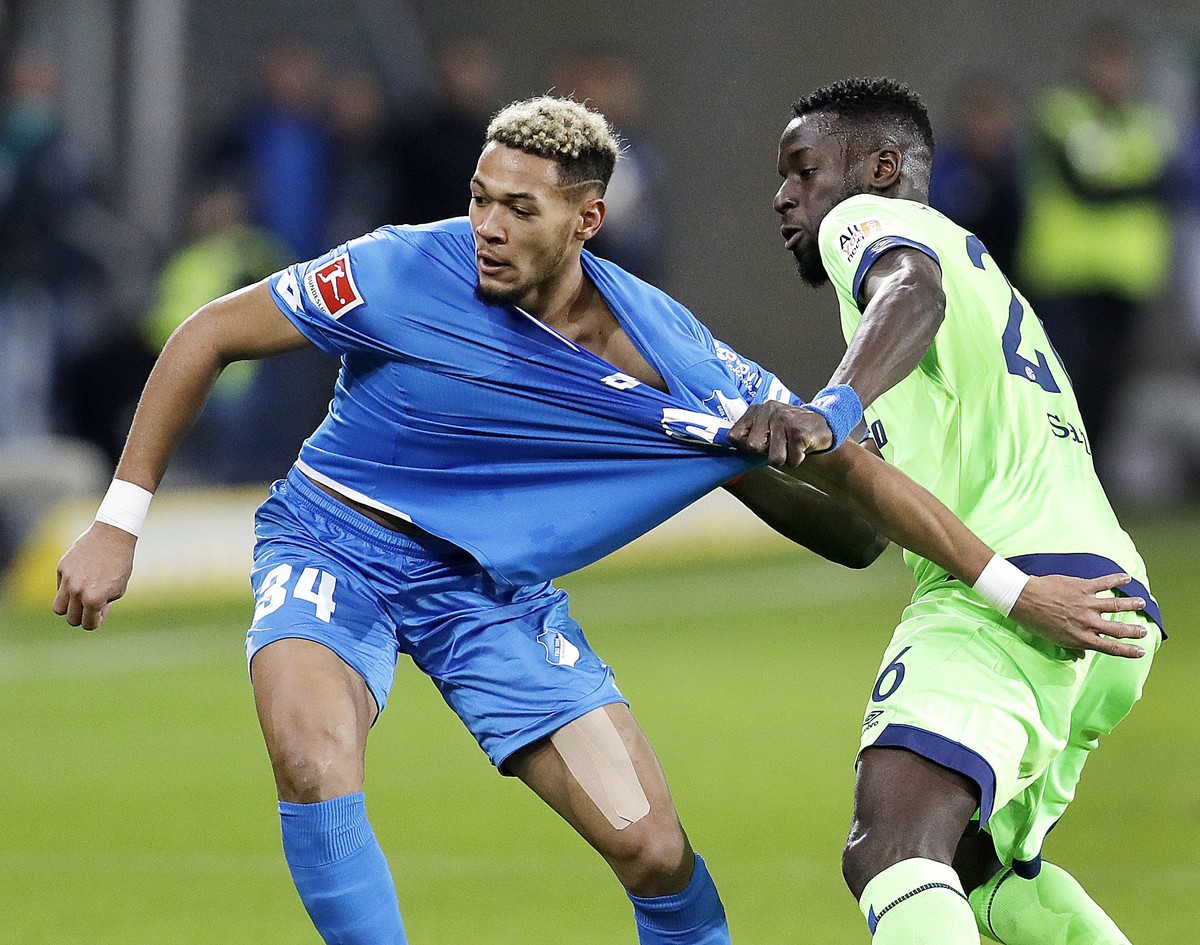 Hoffenheim's Joelinton, left, and Schalke's Salif Sane challenge for the ball during a German Bundesliga soccer match between TSG 1899 Hoffenheim and FC Schalke 04 in Sinsheim, Germany, Satu ...