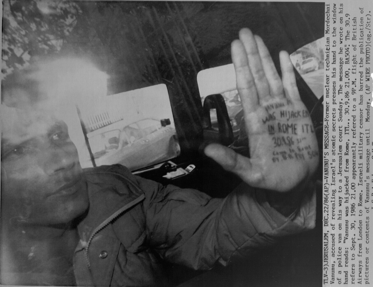 Former nuclear technician Mordechai Vanunu, accused of revealing Israel's atomic secrets, presses his hand to the window of a police van on his way to a Jerusalem court Sunday, Decemver 22, 1987. ...