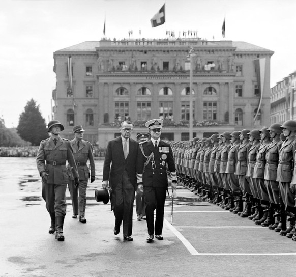 On the occasion of a state visit the Federal counsillor Max Petitpierre, in the center, left, together with the Thai king of Bhumibol Adulyadej, in the center right, is walking over the square Bundesp ...