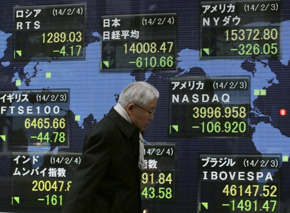 epa04054089 A businessman walks past figures of global stock markets displayed on an electric board during afternoon trade in Tokyo, Japan, 04 February 2014. The benchmark Nikkei 225 Stock Average dipped below the symbolically significant 14,000 mark for the first time since 09 October before rallying, to close the day down 610.66 points, or 4.17 per cent, at 14,008.47, while the broader-based Topix index was down 57.05 points, or 4.77 per cent, at 1,139.27.  EPA/KIMIMASA MAYAMA