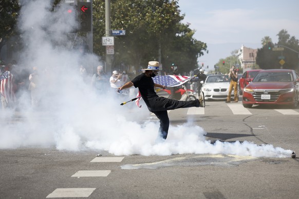 epa12176496 A protester kicks a gas canister as demonstrators clash with law enforcement during a &quot;No Kings Day&quot; protest against President Donald Trump&#039;s policies in Los Angeles, Califo ...