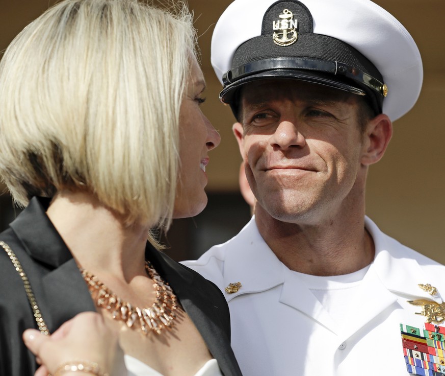 FILE - In this July 2, 2019 file photo, Navy Special Operations Chief Edward Gallagher, right, walks with his wife, Andrea Gallagher as they leave a military court on Naval Base San Diego, in San Dieg ...