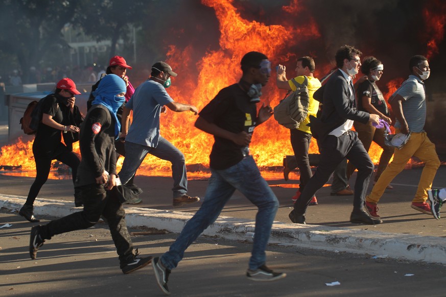 epa05987836 Demonstrators clash with police agents at the Ministeries Esplanade, in Brasilia, Brazil, 24 May 2017. The access to the Agriculture Ministry facilities was attacked with Molotov cocktails ...