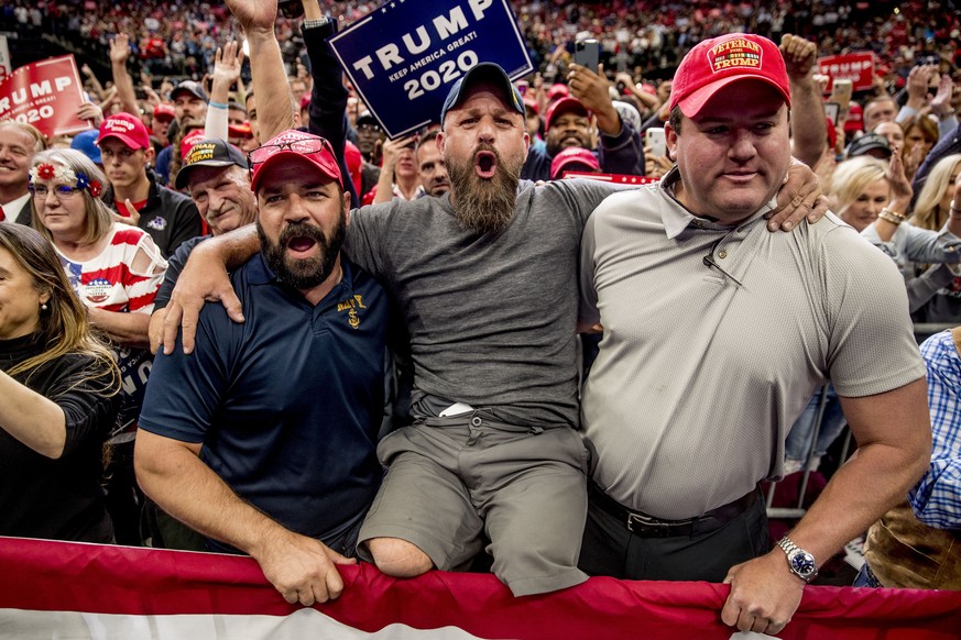 Navy veteran Jase Wheeler of Flower Mound, Texas, who lost his legs after a training injury, jumping out of a Blackhawk helicopter stateside in 2002, cheers with other members of the audience as Presi ...