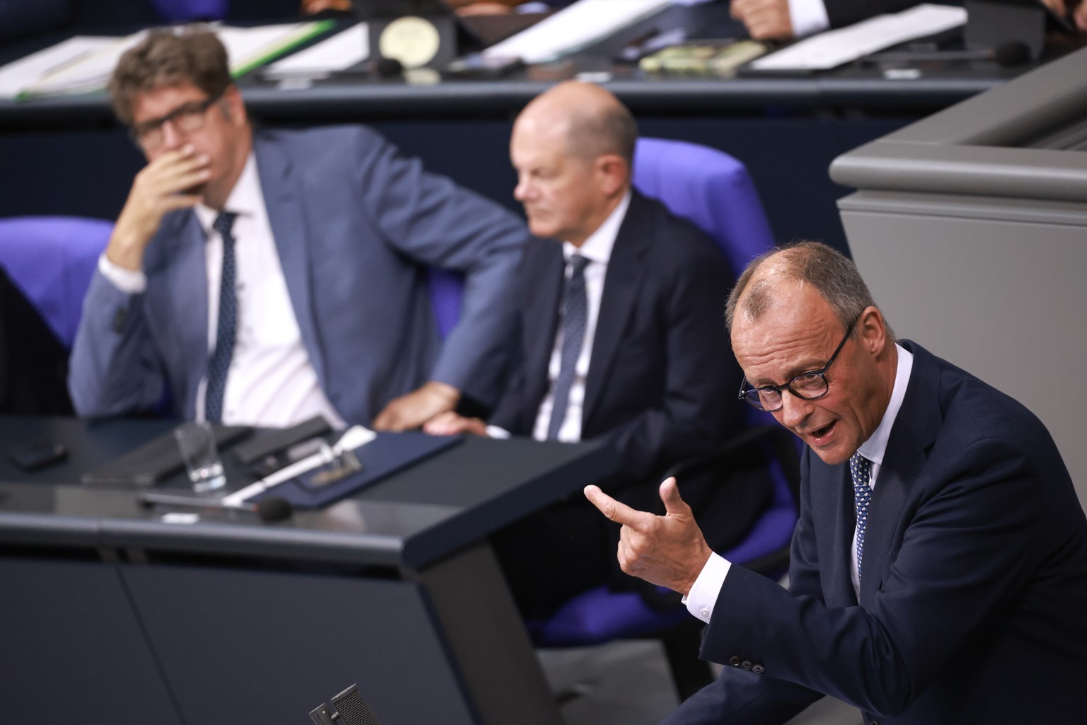 epa11597937 Chairman of the Christian Democratic Union (CDU) party and faction Friedrich Merz (R) gestures as he speaks next to German Chancellor Olaf Scholz (C) and Parliamentary State Secretary at t ...