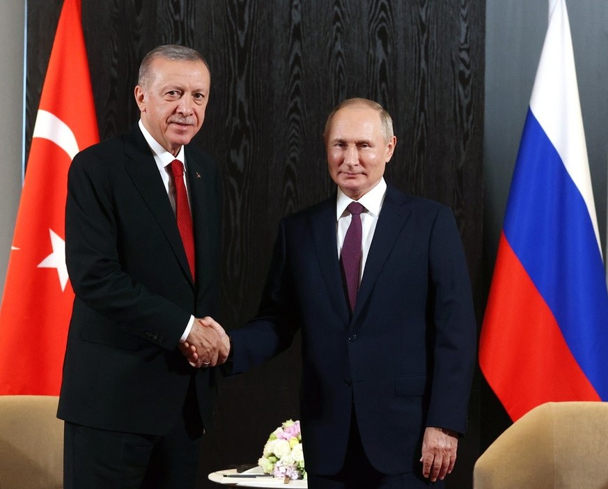 epa10188279 Turkish President Recep Tayyip Erdogan (L) and Russian President Vladimir Putin (R) shake hands during a meeting on the sidelines of the 22nd Shanghai Cooperation Organisation Heads of Sta ...