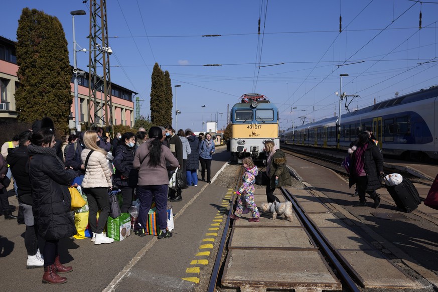 Refugees that fled Ukraine from the war wait to leave the train station in Zahony, Hungary, Sunday, March 6, 2022. (AP Photo/Darko Vojinovic)