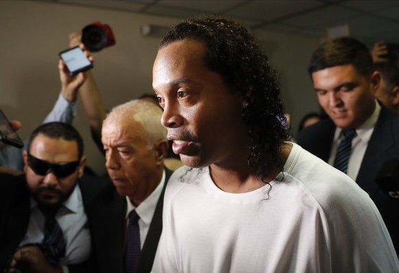Former soccer star Ronaldinho is escorted by police to go before Judge Mirko Valinotti at the Justice Palace court in Asuncion, Paraguay, Friday, March 6, 2020. Ronaldinho has been detained by Paragua ...