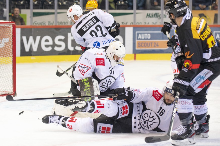 Berns Topscorer Cory Conacher, rechts, kaempft um den Puck gegen Luganos Goalie Leland Irving, und Raphael Herburger, Mitte, im Eishockey Meisterschaftsspiel der National League zwischen dem SC Bern u ...