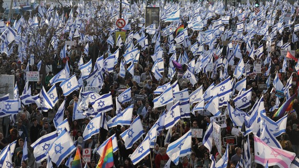 epa10480108 Israeli protesters wave flags during a mass anti-government protest outside Israel's Knesset (parliament), in Jerusalem, Israel, February 20, 2023. Thousands of people protest...