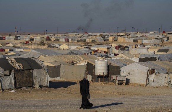 FILE - A woman walks in the al-Hol camp in northeastern Syria&#039;s Hasakeh province, where tens of thousands of mostly women and children linked to the Islamic State group have been living for years ...