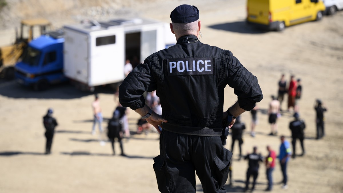 Des policiers de la police cantonale de Fribourg photographies lors d'une operation d'evacutation du rassemblement illegal, rave sauvage ce jeudi 26 mai 2022 a Montagny, Fribourg. Des centai ...