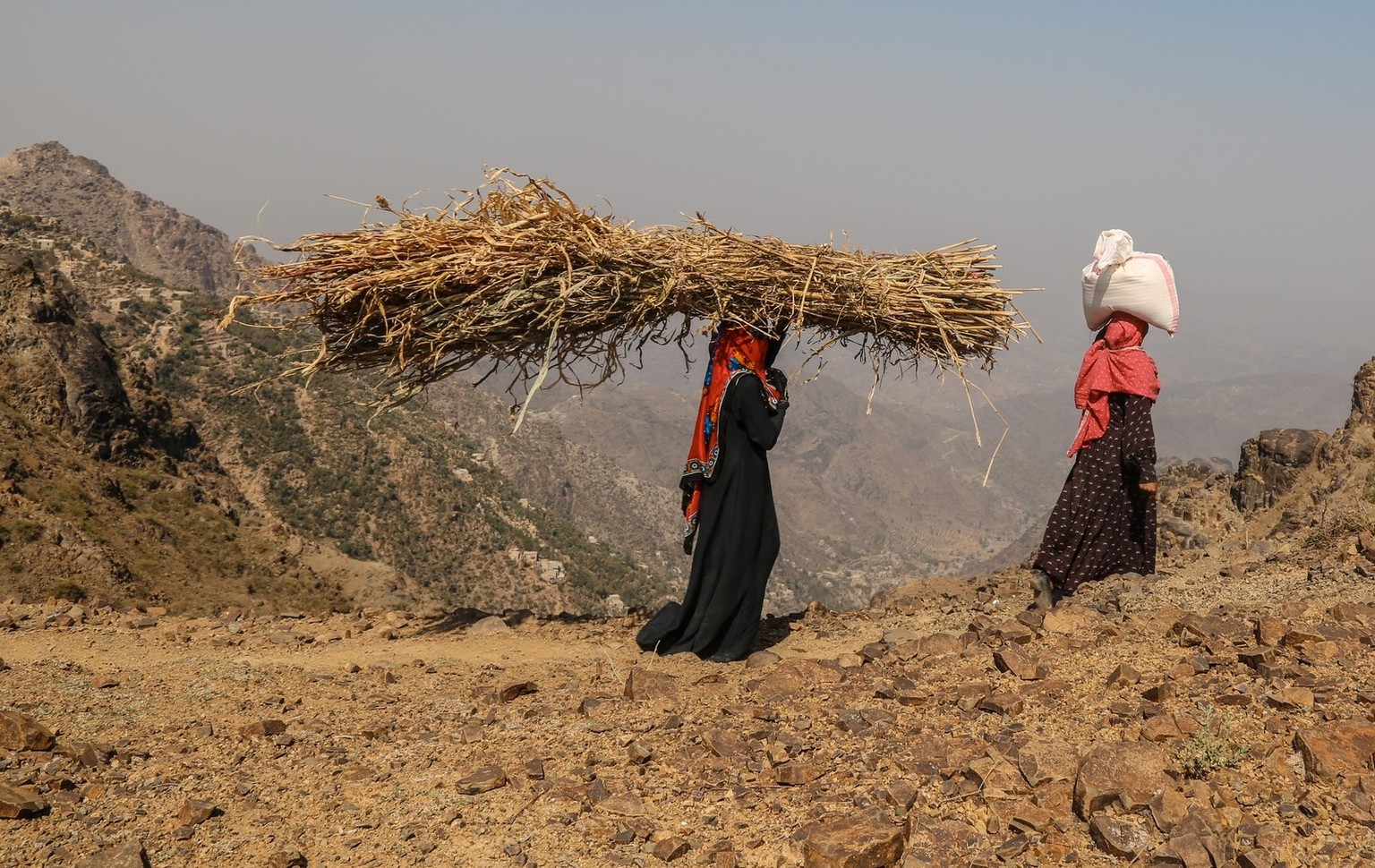 Taiz / Yemen - 02 Apr 2017: Yemeni women bring their food and drink needs across rugged mountain roads due to the Houthi militia blockade of the city of Taiz xkwx a human tragedy, a street person, agg ...
