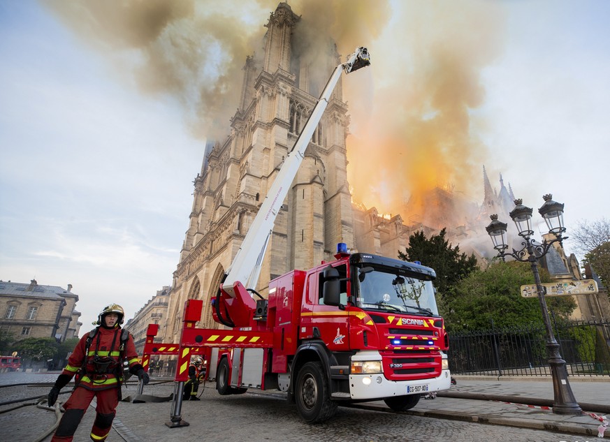 This photo provided on Tuesday April 16, 2019 by the Paris Fire Brigade shows fire fighters working at the burning Notre Dame cathedral, Monday April 15, 2019. Experts assessed the blackened shell of  ...