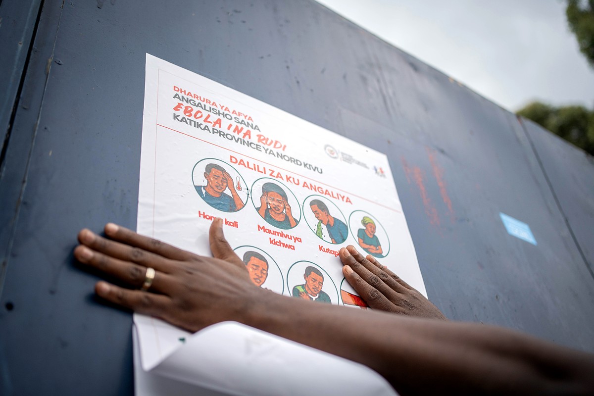 KEYPIX - epa12978406 A staff with the non-governmental organization AGIR-RDC that promotes medical access, displays a poster describing preventive measures against Ebola, in Goma, North Kivu, Democrat ...