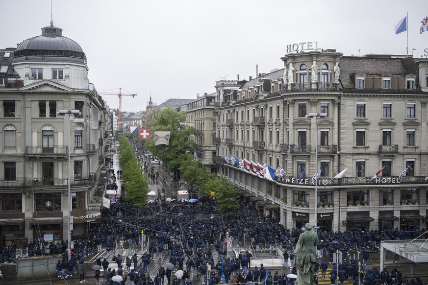 Polizisten schuetzen die Laeufer vor dle FCZ Fans an der Bahnhofstrasse am den 21. Zuercher Marathon ein, aufgenommen am Sonntag, 21. April 2024 in Zuerich. (KEYSTONE/Ennio Leanza)