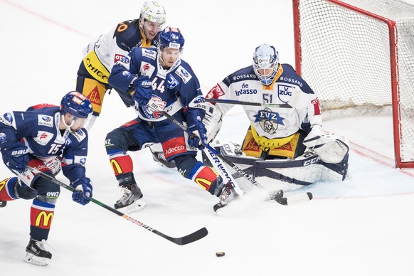 Zuercher Mathias Seger, links, und Pius Suter, spielen um den Puck gegen Zugs Torhueter Tobias Stephan, rechts, im vierten Eishockey Playoff-Viertelfinalspiel der National League zwischen den ZSC Lion ...