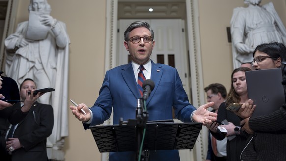 Speaker of the House Mike Johnson, R-La., talks briefly to reporters just before a vote on an amended interim spending bill to prevent a government shutdown, at the Capitol in Washington, Thursday, De ...