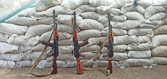 Three Kalashnikovs standing near sandbagged fortifications. kalashnikov assault rifle ak74n standing at barricade. AK-74. Soviet weapon. Assault rifle of struggle. Equipment for war. AK-74 outdoor xkw ...