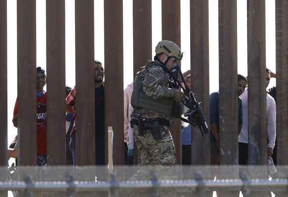 U.S. Customs and Border Protection officers walks along a wall at the border between Mexico and the United States, as seen from San Diego on Sunday, Nov. 25, 2018. Migrants approaching the U.S. border ...