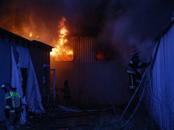 epa10361106 Firefighters extinguish a blaze at a toy shop after rockets hit it in downtown Donetsk, Ukraine, 11 December 2022. During the last five days of shelling, 11 people were killed and 25 injur ...