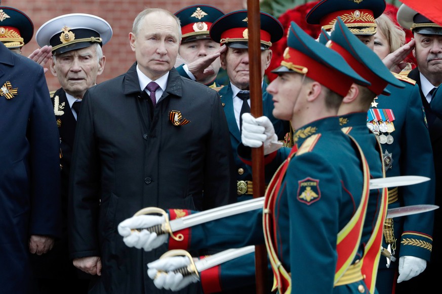 FILE - Russian President Vladimir Putin, center, attends a wreath-laying ceremony at the Tomb of the Unknown Soldier after the Victory Day military parade in Moscow, Russia, May 9, 2021. The defeat of ...