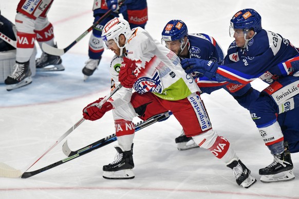 Der Laker, Kevin Clark, links, vor den Lions Dario Trutmann, Mitte, und Reto Schaeppi, rechts, beim Eishockeyspiel der National League A ZSC Lions gegen die SC Rapperswil-Jona Lakers im Hallenstadion  ...