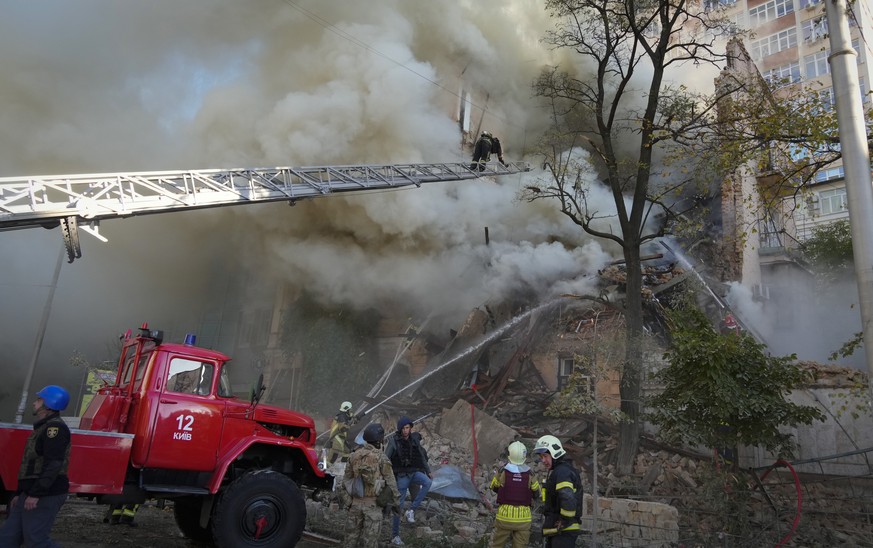 Firefighters work after a drone fired on buildings in Kyiv, Ukraine, Monday, Oct. 17, 2022. (AP Photo/Efrem Lukatsky)