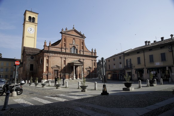 Two reporters stand in front of the San Biagio Church in Codogno, near Lodi, Northern Italy, Saturday, Feb. 22, 2020. A dozen northern Italian towns were on effective lockdown Saturday after the new v ...