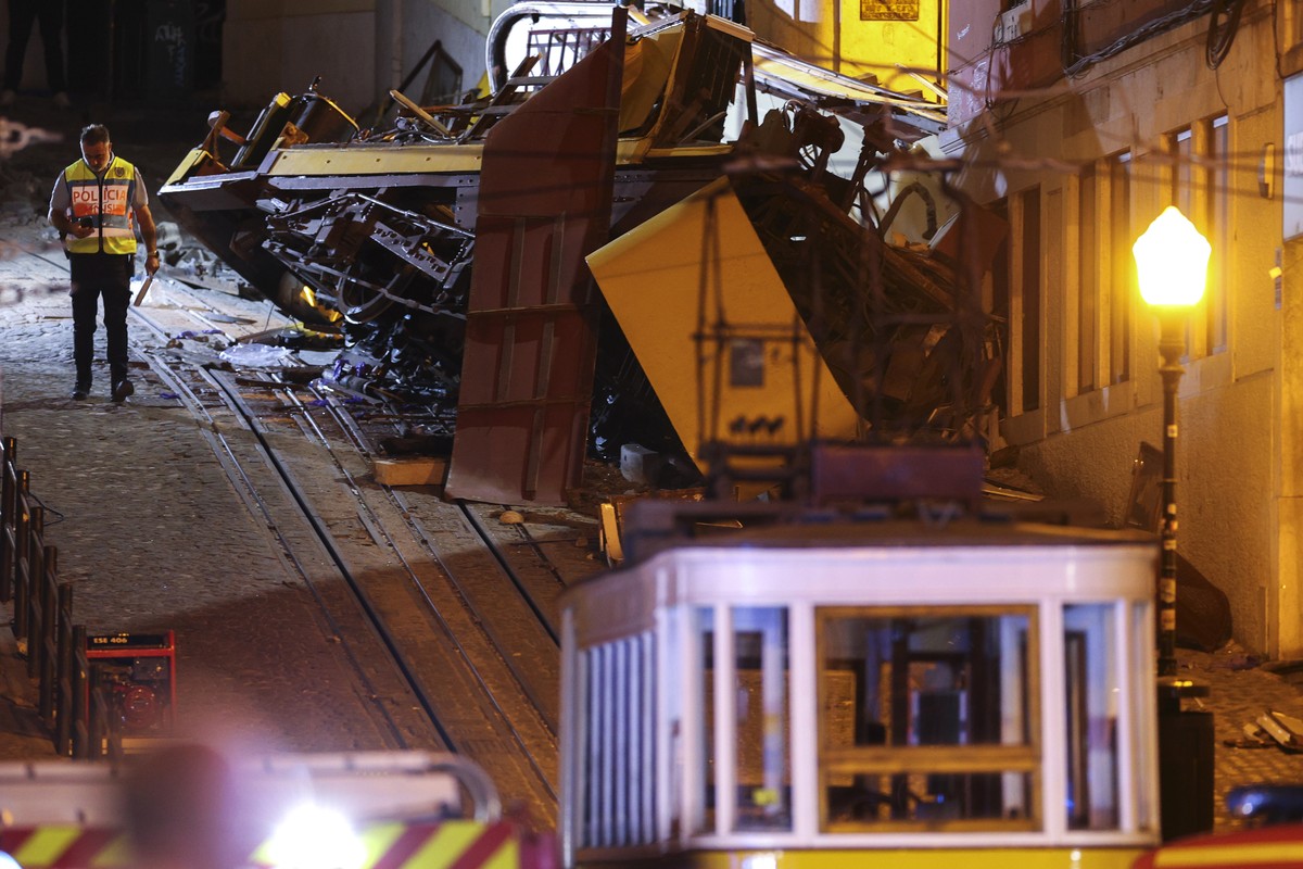 epaselect epa12350498 A police officer stand at the scene after the Gloria funicular cable railway derailed in Lisbon, Portugal, 03 September 2025. At least 15 people died in the derailment and 18 oth ...