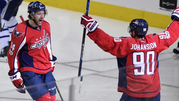 Washington Capitals right wing Justin Williams (14) celebrates his winning goal with Marcus Johansson (90), of Sweden, in the overtime of Game 5 in an NHL Stanley Cup hockey first-round playoff series ...
