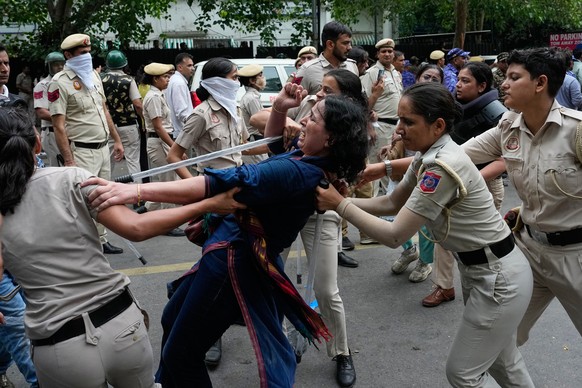 Police detains a supporter of the Cockroach Janta Party as they attempt to march toward India's Parliament, demanding the resignation of the education minister, in New Delhi, India, Monday, July  ...