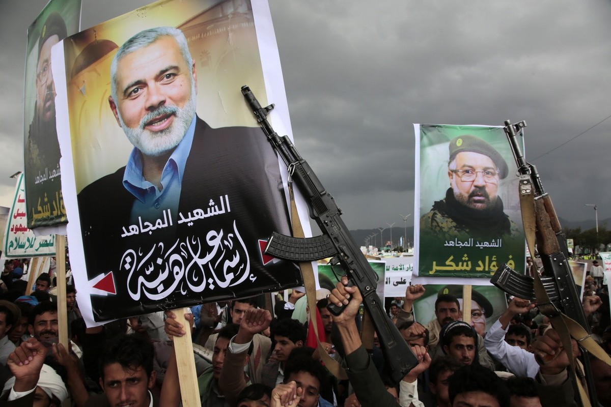 epa11519630 Houthi supporters hold placards with pictures of late Hamas political leader Ismail Haniyeh and Hezbollah senior commander Fuad Shukr during a protest following their deaths, in Sana' ...
