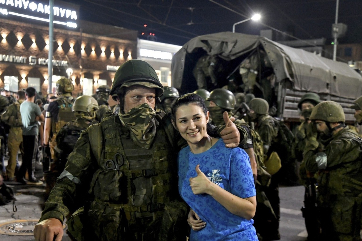 epa10710232 A local woman poses with a soldier from the Wagner Group of the Private Military Company (PMC) as he prepares to leave the center of Rostov-on-Don, southern Russia, June 24, 2023.  Security and armored vehicle ...