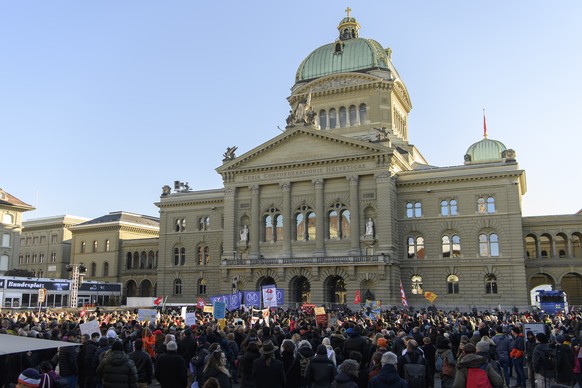 Demonstranten protestieren vor das Bundeshaus, gegen die Massnahmen im Zusammenhang mit dem Coronavirus, am Samstag, 22. Januar 2022, auf dem Bundesplatz, in Bern. (KEYSTONE/Anthony Anex)