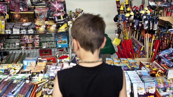 ZUM FEUERWERKSVERBOT FUER DEN ERSTEN AUGUST IM KANTON BERN STELLEN WIR IHNEN AM DONNERSTAG, 23. JULI 2015, FOLGENDES ARCHIVBILD ZUR VERFUEGUNG - Ein Kind steht vor einer grossen Auswahl an Feuerwerk a ...