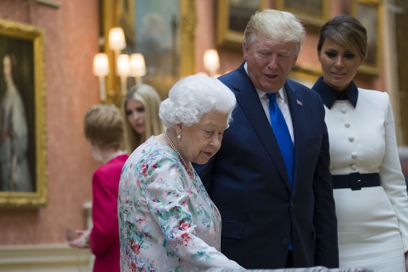 Queen Elizabeth II, first lady Melania Trump and President Donald Trump look at items in the Royal Gifts collection at Buckingham Palace, Monday, June 3, 2019, in London. (AP Photo/Alex Brandon)