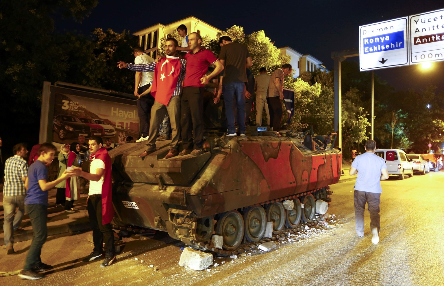 Supporters of Turkish President Tayyip Erdogan stand on an abandoned tank during a demonstration outside parliament building in Ankara, Turkey, July 16, 2016. REUTERS/Osman Orsal