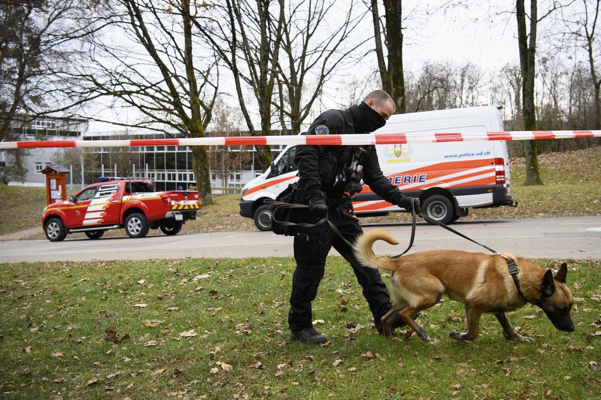 Une policier de la brigade canine de la police cantonale vaudoise marche avec son chien devant l' Ecole professionnelle commerciale de Lausanne (EPCL) lors d'une alerte a la bombe ce mercred ...