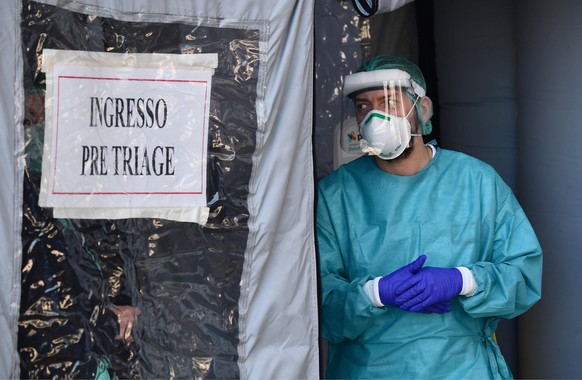epa08298246 Health workers of the Genoa White Cross wearing protective masks and overalls prepare to pick up patients suspected of having Covid-19 coronavirus, in Genoa, Italy, 16 March 2020. Tough lo ...