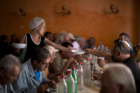 Needy people eat at the Church-run Galini charity&#039;s soup kitchen in central Athens on Monday, July 6, 2015. GreeceÂs finance minister has resigned following SundayÂs referendum in which the maj ...