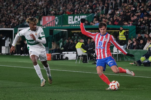 epa11827989 Elche&#039;s defender John Donald (L) views for the ball with midfielder Rodrigo Riquelme (R), of Atletico Madrid, during their King&#039;s Cup round of 16 game at Martinez Valero Stadium, ...