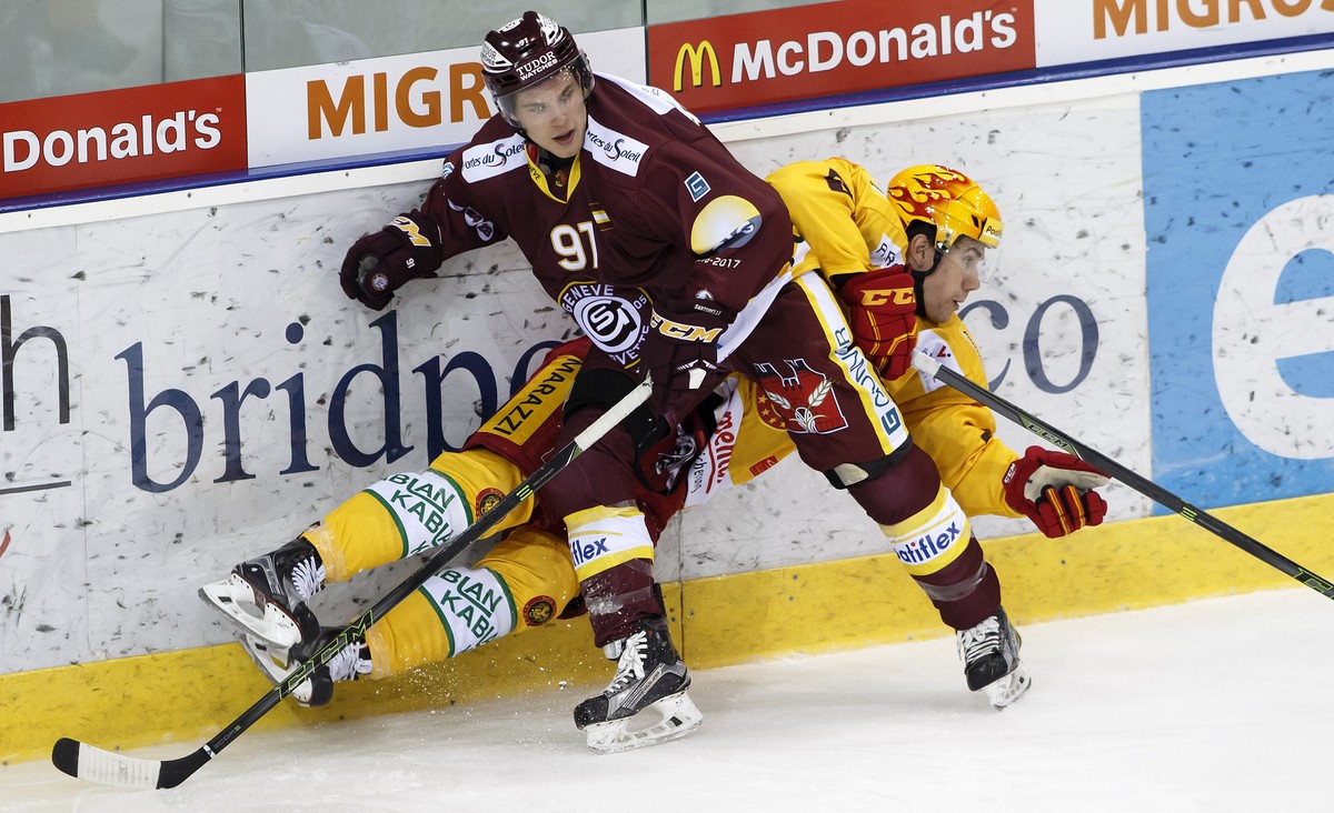 Geneve-Servette's centre Mike Santorelli, of Canada, left, vies for the puck with Tigers' centre Yannick-Lennart Albrecht, right, during the game of National League A (NLA) Swiss Championshi ...
