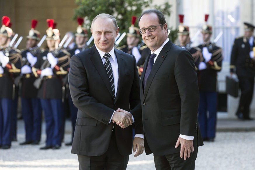 epa04960042 Russian President Vladimir Putin (L) is welcomed by French President Francois Hollande (R) as he arrives at the Elysee Palace for a summit on Ukraine, in Paris, France, 02 October 2015. Ge ...