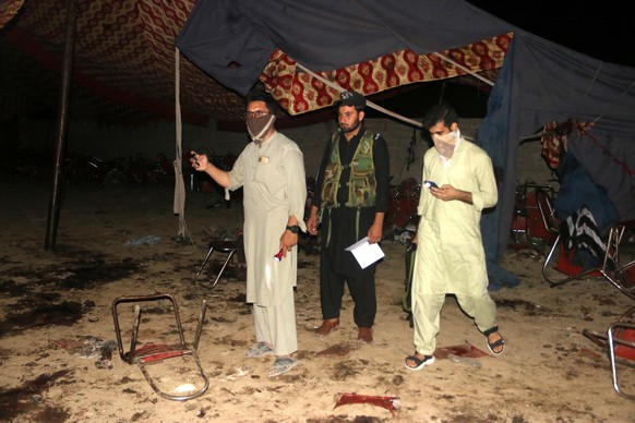 epa10777747 People survey the site of a blast targeting a gathering of Islamic political party Jamiat Ulma-e-Islam (JUI-F) in Bajaur, Pakistan, 30 July 2023. At least 40 people were killed and several ...