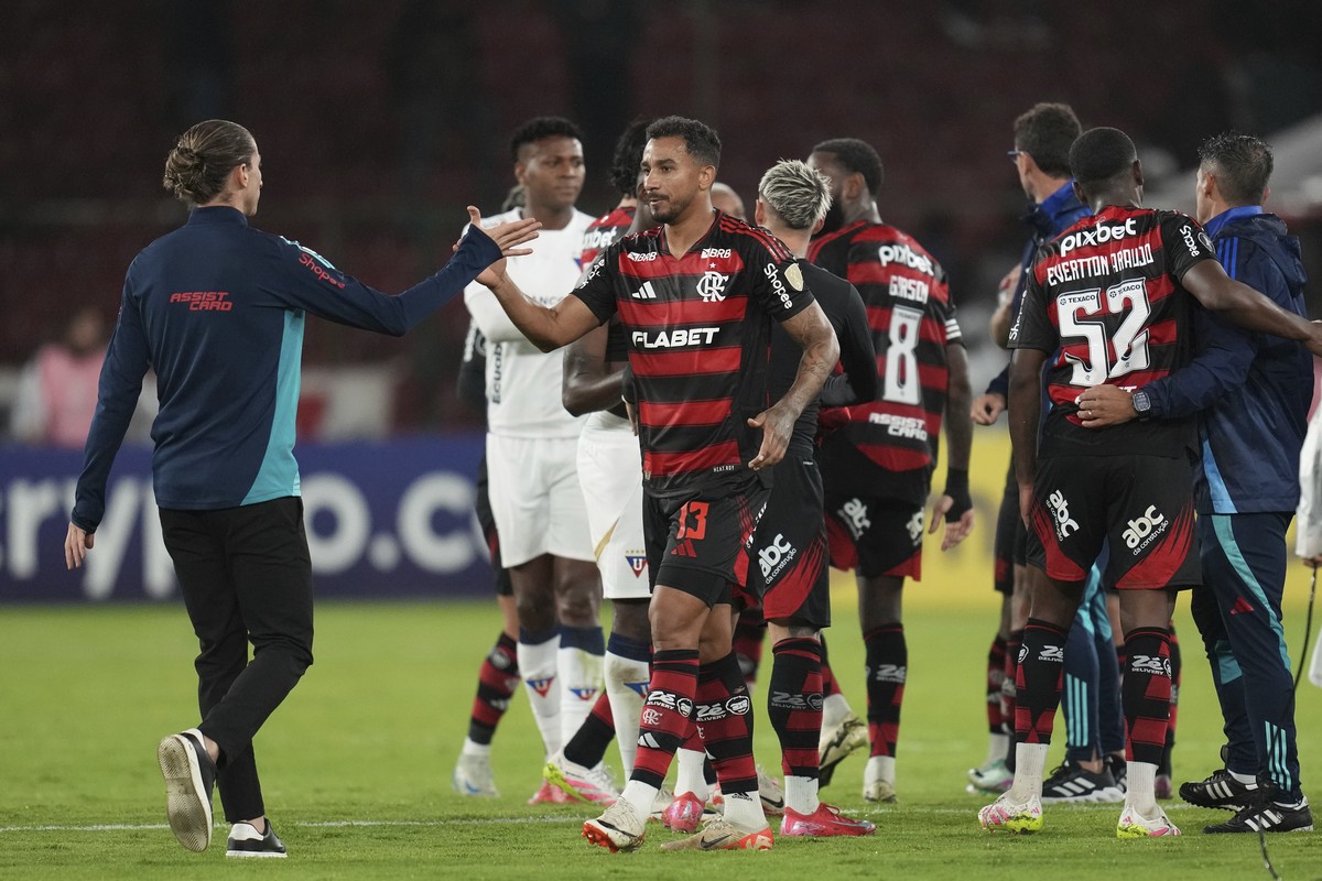 Danilo of Brazil's Flamengo, center, is congratulated by his team's coach Filipe Luis after a 0-0 tie against Ecuador's Liga Deportiva Universitaria at the end a Copa Libertadores Group ...