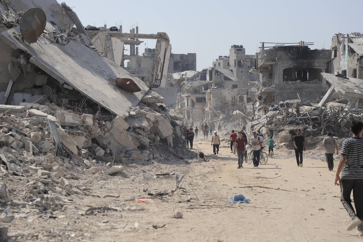 240711 -- GAZA, July 11, 2024 -- People are seen on a street with destroyed buildings in the Shujaiya neighborhood in east of Gaza City, on July 11, 2024. More than 60 bodies were recovered from the r ...