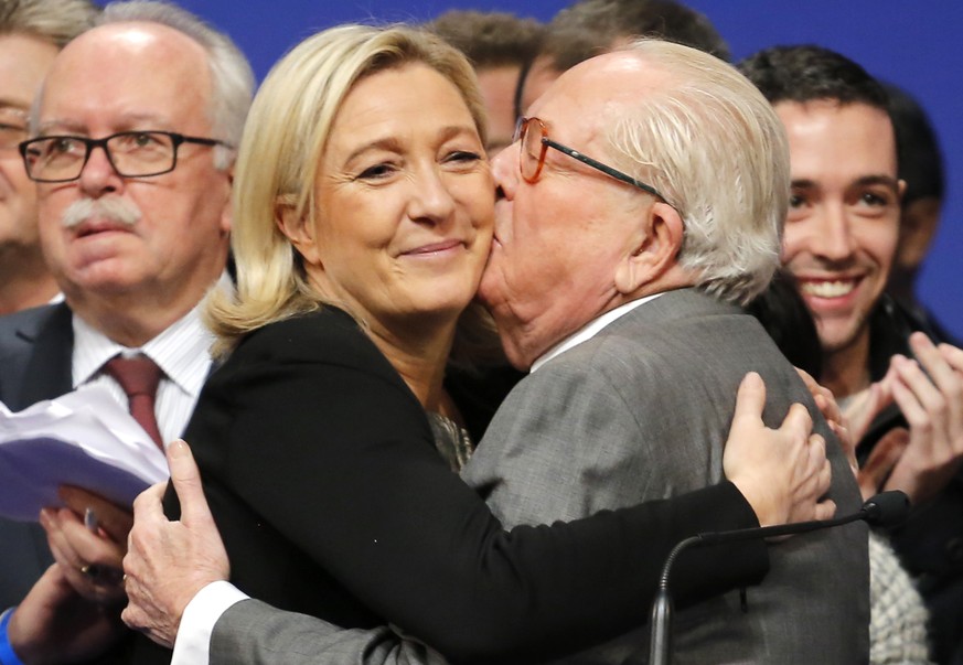 FILE - In this Sunday Nov. 30 2014, file photo, French far-right Front National leader Marine Le Pen is kissed by her father Jean-Marie Le Pen after being re-elected as president of the party during t ...
