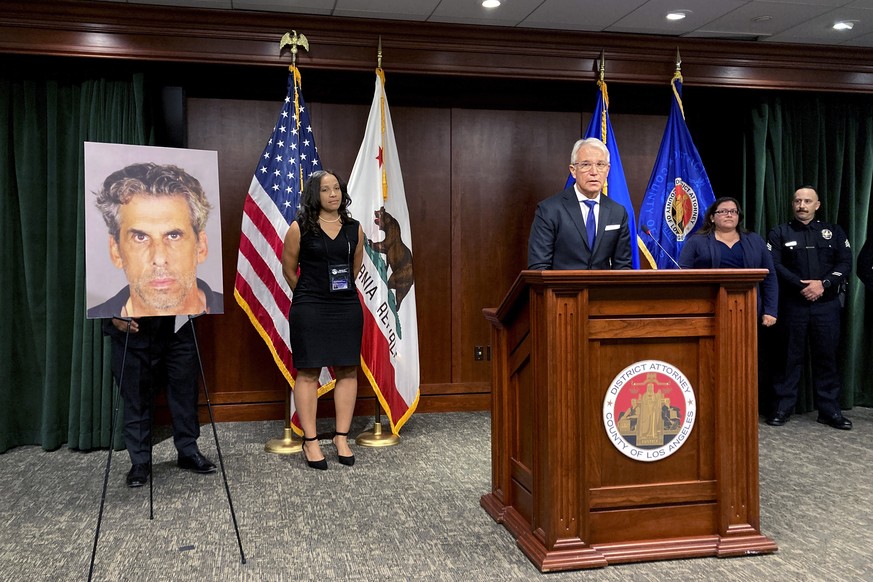 Los Angeles District Attorney George Gascon, at podium stands by a photo on display of TV producer Eric Weinberg during a news conference to announce sexual assault charges against Weinberg on Wednesd ...