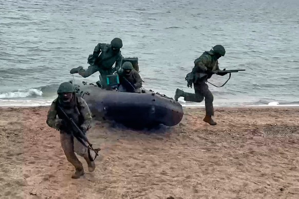 In this photo taken from video provided by Russian Defense Ministry Press Service on Thursday, Dec. 25, 2025, Russian soldiers leave a boat to set ensure reliable communications in an undisclosed loca ...